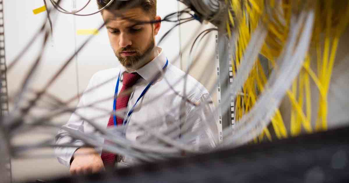Technician checking cables in a rack mounted server while IT equipment moving