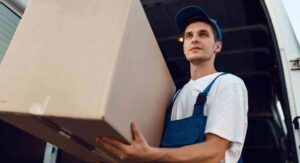 Loader in uniform holding box for long-distance moving.