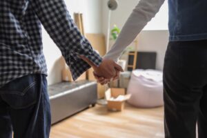 Closeup of a couple holding hands after deciding to follow moving trends 2025 like relocating to smaller cities.