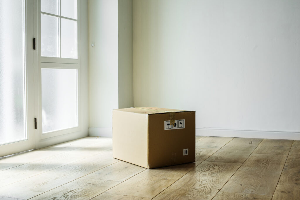 One box in an empty room which represents things people forget when moving without a moving checklist.
