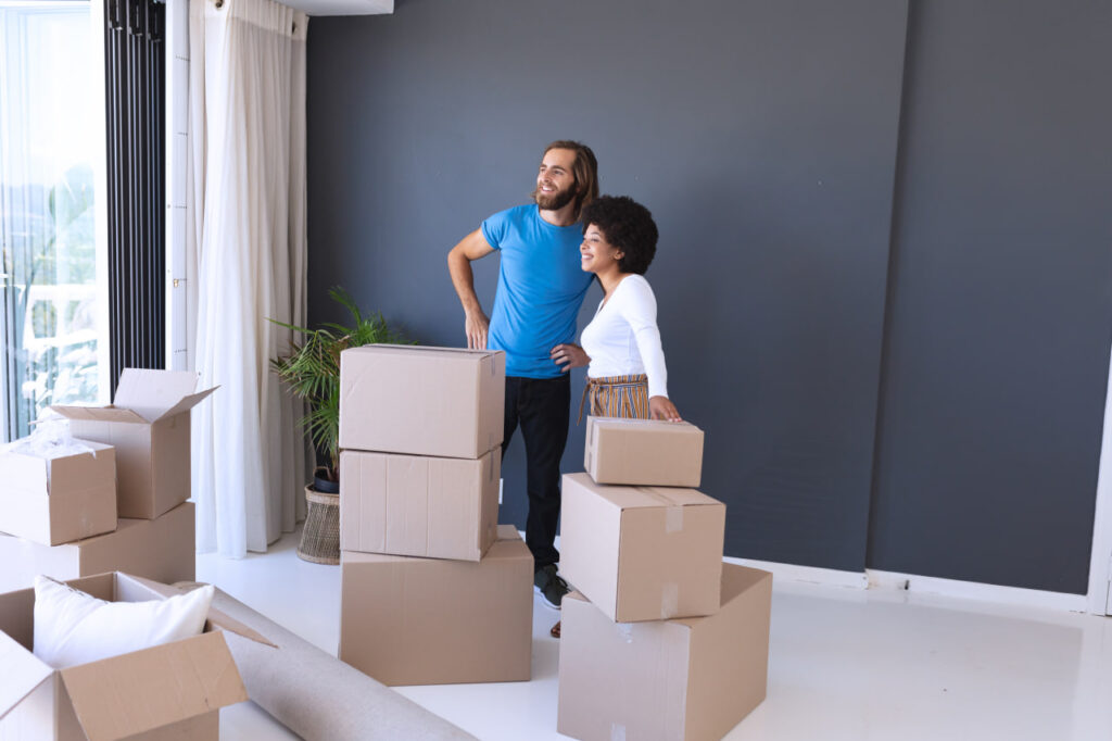 Happy couple with packed boxes, relocating for work to one of the best cities for workers. 