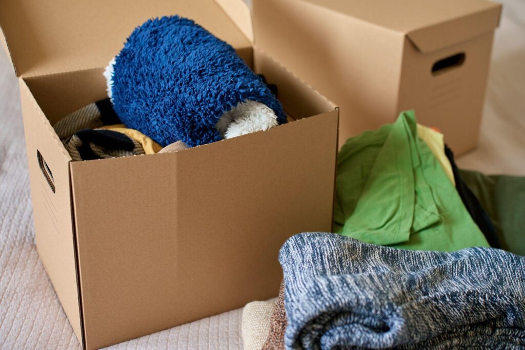 A box filled with items to declutter for people who want to know how to save money on a professional move.