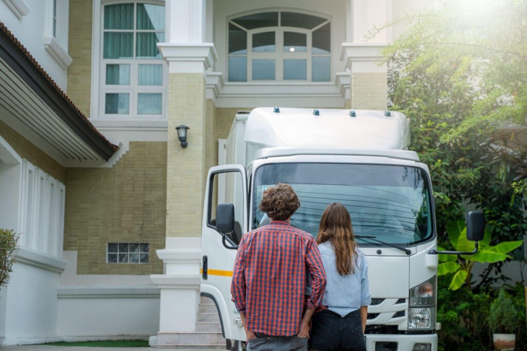 A couple facing a moving truck taking their items to storage as cost-effective moving strategies.